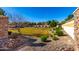 Community green space features a grassy area, shrubbery, and stone retaining walls on a sunny day at 8515 W Peppertree Ln, Glendale, AZ 85305