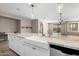 Kitchen island featuring granite countertop, a farmhouse sink, stainless steel dishwasher, and barstool seating at 8515 W Peppertree Ln, Glendale, AZ 85305