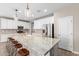 Modern kitchen with a large granite island, stainless steel appliances, and white cabinetry at 8515 W Peppertree Ln, Glendale, AZ 85305