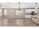 Open concept living area with wood-look tile floors, white cabinets, and a granite countertop island with barstool seating at 8515 W Peppertree Ln, Glendale, AZ 85305