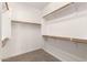 Walk-in closet featuring carpeted floors, multiple shelves and copper rods at 8515 W Peppertree Ln, Glendale, AZ 85305