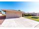 Attached garage with concrete driveway and lush, well-maintained landscaping at 10420 W Tropicana Cir, Sun City, AZ 85351