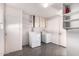 Laundry room with washer, dryer, cabinets, and shelving at 10420 W Tropicana Cir, Sun City, AZ 85351