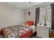 Well-lit bedroom featuring a cozy bed, a patterned quilt, a neutral color scheme, and a wooden nightstand at 10515 W Pasadena Ave, Glendale, AZ 85307