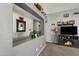 Open living space with a gray wall, mirror, decorations, and an entertainment stand with an electric fireplace at 10515 W Pasadena Ave, Glendale, AZ 85307