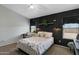 Comfortable bedroom featuring an accent wall, ceiling fan, and a bedside table with lamps for a cozy atmosphere at 10515 W Pasadena Ave, Glendale, AZ 85307