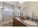 Bathroom with double sinks, wood cabinets, and tiled floors at 10558 E Meadowhill Dr, Scottsdale, AZ 85255