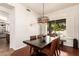 Bright dining room with a modern chandelier and a view of the backyard pool at 10558 E Meadowhill Dr, Scottsdale, AZ 85255