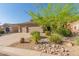 A beautiful home with a three-car garage and well-maintained desert landscaping with desert trees and native plants at 10558 E Meadowhill Dr, Scottsdale, AZ 85255