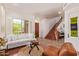 Bright living room with plantation shutters, hardwood floors, an adjacent staircase and front door at 10558 E Meadowhill Dr, Scottsdale, AZ 85255