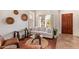 Bright living room with plantation shutters, hardwood floors, an adjacent dining area and front door at 10558 E Meadowhill Dr, Scottsdale, AZ 85255