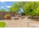 Outdoor lounging area with a shaded daybed on a gravel patio surrounded by lush desert vegetation at 10558 E Meadowhill Dr, Scottsdale, AZ 85255