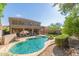 An inviting backyard pool features a waterfall, covered patio, lush landscaping, and desert-style rock at 10558 E Meadowhill Dr, Scottsdale, AZ 85255