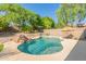 Outdoor pool features a rock waterfall, tropical umbrella, and serene landscaping for a relaxing backyard oasis at 10558 E Meadowhill Dr, Scottsdale, AZ 85255