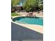 Inviting pool with a rock waterfall feature, complemented by lush greenery and a stone surround at 10558 E Meadowhill Dr, Scottsdale, AZ 85255