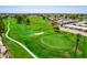 Aerial view of golf course with lush green fairways, sand traps, surrounding residences, and manicured green at 1132 S 81St Pl, Mesa, AZ 85208