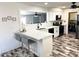 Well-lit kitchen featuring a breakfast bar, modern appliances, and stylish wood-look floors at 1132 S 81St Pl, Mesa, AZ 85208