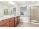 This bathroom features double sinks, an over-sized mirror, a bathtub, and a shower with glass doors at 12603 W Blackstone Ln, Peoria, AZ 85383