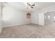 This primary bedroom features carpet floors, neutral colored walls, a ceiling fan, and a door to the bathroom at 12603 W Blackstone Ln, Peoria, AZ 85383