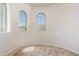 Bonus room with arched windows showcasing neighborhood views and neutral carpet at 12603 W Blackstone Ln, Peoria, AZ 85383