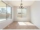 This dining room features tile floors, neutral walls, a modern chandelier, and many windows allowing for lots of natural light at 12603 W Blackstone Ln, Peoria, AZ 85383