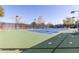 Community tennis court with green and blue surface, surrounded by a fence and mature trees at 12603 W Blackstone Ln, Peoria, AZ 85383