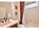 Bathroom featuring a single sink vanity, tiled backsplash, tub with shower and neutral colors at 13055 W Cliffrose Rd, Peoria, AZ 85383