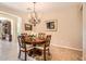 Elegant dining room featuring a round wooden table, chandelier, and neutral decor at 13055 W Cliffrose Rd, Peoria, AZ 85383