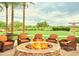 Outdoor fire pit with comfortable seating and picturesque views of the lush green golf course at 13055 W Cliffrose Rd, Peoria, AZ 85383