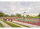 A view of the community tennis courts surrounded by lush greenery and enhanced by court-side lighting at 13055 W Cliffrose Rd, Peoria, AZ 85383