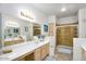 Well-lit bathroom featuring dual sinks, large mirror, vanity, and tiled walk-in shower at 15252 N 100Th St # 2141, Scottsdale, AZ 85260