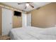 This bedroom features carpeted floors, ceiling fan, and a television mounted on the wall at 1604 W Kerry Ln, Phoenix, AZ 85027