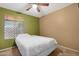 This bedroom features neutral carpet, a ceiling fan and a window overlooking the exterior of the home at 1604 W Kerry Ln, Phoenix, AZ 85027