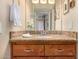 Bathroom vanity with granite countertop, wood cabinets, and decorative mirror, complemented by fresh flowers and towels at 16657 E Gunsight Dr # 181, Fountain Hills, AZ 85268