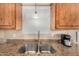 Stainless steel sink with granite countertops and wooden cabinets is complemented by a view from the window at 16657 E Gunsight Dr # 181, Fountain Hills, AZ 85268