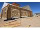 New construction shows wall and roof framing of a home in a desert landscape under a blue sky at 1800 W Caramel Ct, Queen Creek, AZ 85144