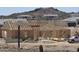 New construction shows wall and roof framing of a home in a desert landscape with other homes nearby at 1800 W Caramel Ct, Queen Creek, AZ 85144