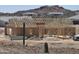 New construction shows wall and roof framing of a home in a desert landscape with other homes nearby at 1800 W Caramel Ct, Queen Creek, AZ 85144