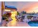 Outdoor patio space with a table and chairs near a pool and desert landscaping at 19793 N Tapestry Ct, Surprise, AZ 85374