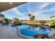 Beautiful backyard swimming pool with rock features and view of the community golf course at 19793 N Tapestry Ct, Surprise, AZ 85374