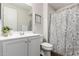 Well lit bathroom featuring a white vanity and floral shower curtain at 22854 E Pummelos Rd, Queen Creek, AZ 85142