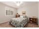 Cozy bedroom featuring a floral bedspread and window with shutters at 22854 E Pummelos Rd, Queen Creek, AZ 85142