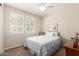 Cozy bedroom with plantation shutters for natural light and comfortable carpeting and ceiling fan at 22854 E Pummelos Rd, Queen Creek, AZ 85142