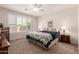 Comfortable bedroom with plush carpet, ceiling fan, and plantation shutters for natural light at 22854 E Pummelos Rd, Queen Creek, AZ 85142