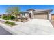 Inviting single-story home with a well-manicured lawn and desert landscaping leading to a two-car garage at 22854 E Pummelos Rd, Queen Creek, AZ 85142