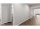 Hallway with wood-look floors leads to various rooms, showcasing the home's open layout at 22854 E Pummelos Rd, Queen Creek, AZ 85142