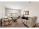 Comfortable living room with plush furniture, neutral decor, and natural light from the window with plantation shutters at 22854 E Pummelos Rd, Queen Creek, AZ 85142