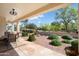 Covered back patio with outdoor dining and manicured desert landscaping creates a serene outdoor living space at 23123 N Cardenas Dr, Sun City West, AZ 85375