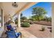 Spacious covered patio with stone tile, a ceiling fan, and desert landscaping for outdoor enjoyment at 23123 N Cardenas Dr, Sun City West, AZ 85375