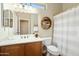 Well-lit bathroom with a single sink vanity and shower with white curtain at 23123 N Cardenas Dr, Sun City West, AZ 85375